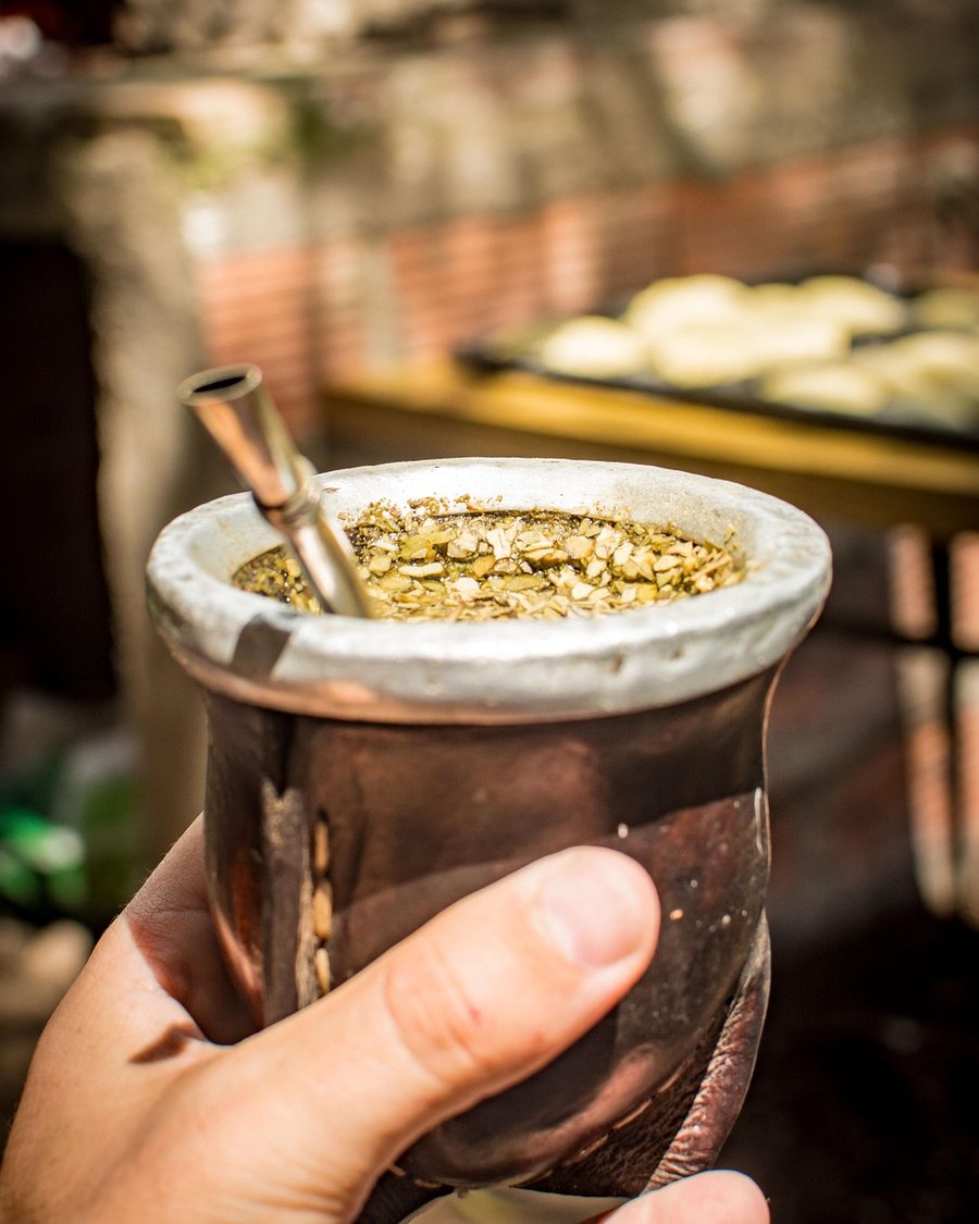 Mate-Becher mit Bombilla in der Hand